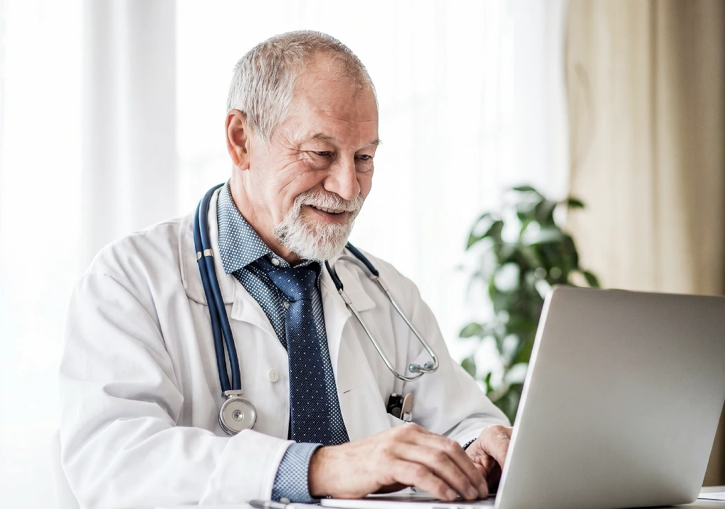 A practitioner managing his schedule on a laptop