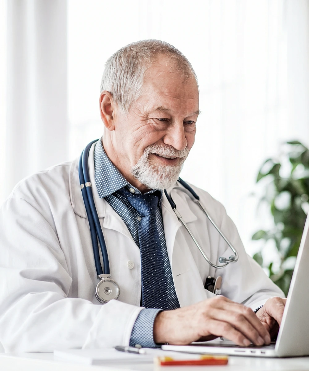 A practitioner managing his schedule on a laptop